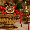 Eine goldene Schale mit roten Beeren und Hagebutten im typisch weihnachtlichen Stil.